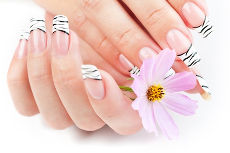 Hands with striped manicure relaxing with flowersの写真素材