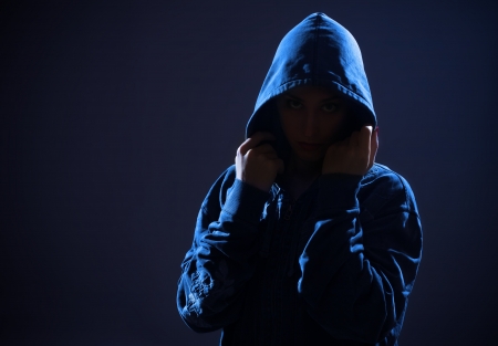 woman with hood in darknessの写真素材