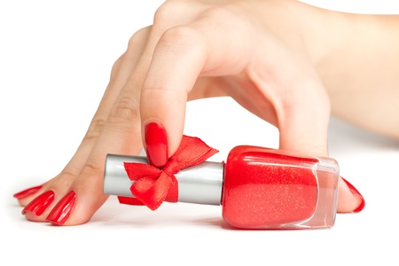 woman s hand with a bottle of red nail polishの写真素材