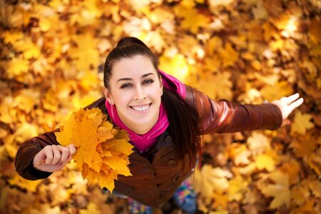 cute girl on a background of  autumn leafs  top viewの写真素材