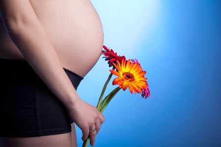 beautiful pregnant woman with flowersの写真素材