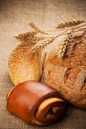 assortment of fresh baked bread on burlap backgroundの写真素材