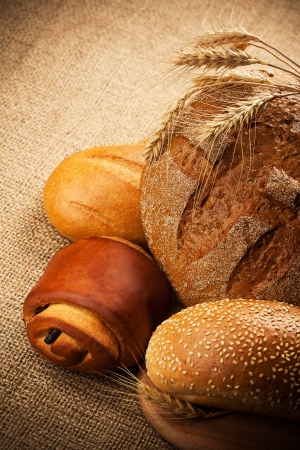 assortment of fresh baked bread on burlap backgroundの写真素材