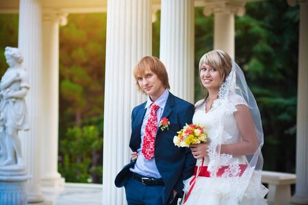 happy bride and groom near white columnの写真素材