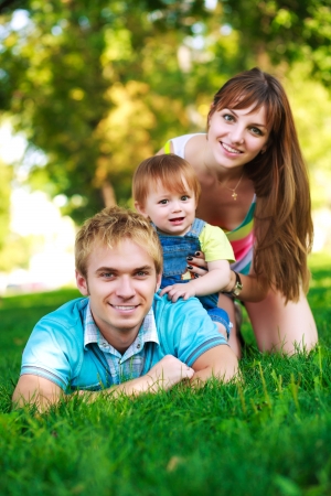 baby with parents in a beautiful summer parkの写真素材