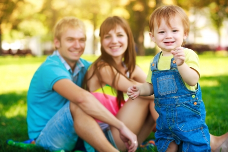 smiling baby with parents in a beautiful summer parkの写真素材