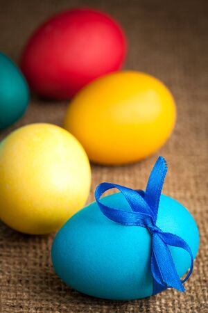 colored Easter eggs on the burlap backgroundの写真素材