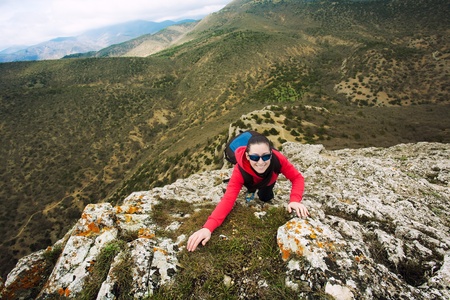 woman climber is climbing on a rockの写真素材