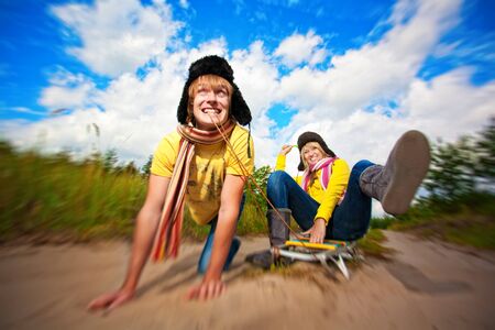 crazy boy and girl are sledding at summerの写真素材
