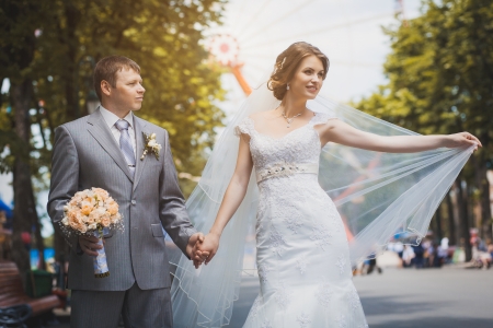 happy bride and groom are hugging in the green parkの写真素材