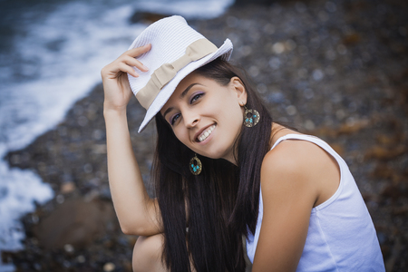 girl is sitting on the rock on the beachの写真素材