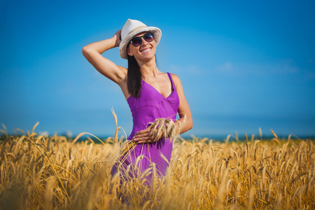 beautiful girl is picking flowers on the yellow  fieldの写真素材