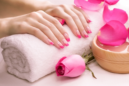 pink manicure with fragrant rose petals and towelの写真素材