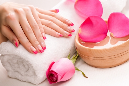 pink manicure with fragrant rose petals and towelの写真素材