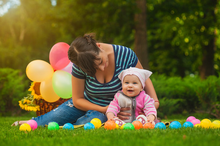 baby and mom are playing on the green grassの写真素材