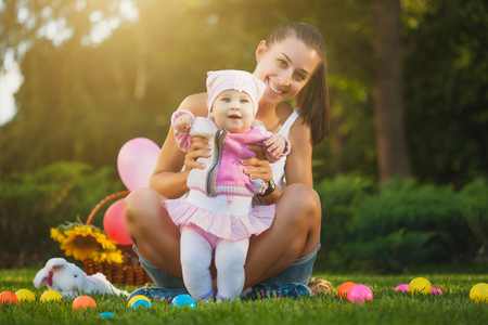 baby and mom are playing on the green grassの写真素材