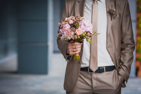 newlywed's hands on the wedding bouquetの写真素材