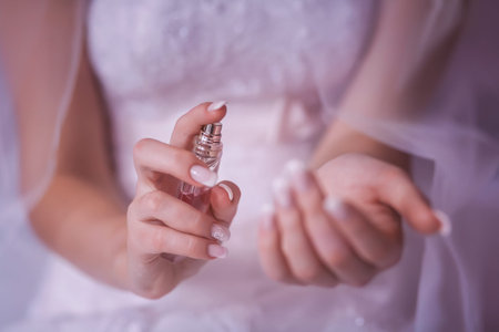 woman applying perfume on her wrist, bright red perfume bottle