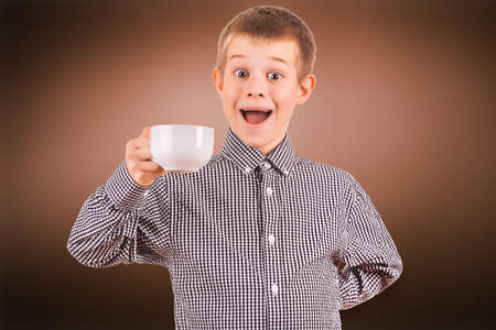 cute boy with white cup of teaの写真素材