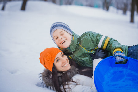 happy mother and son playing on the snow