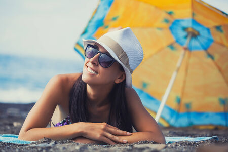 beautiful girl is sunbathing on the beachの写真素材