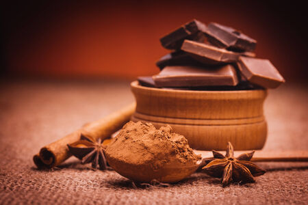 pieces of chocolate with spices, cinnamon, star anise on the burlapの写真素材