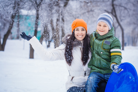 happy mother and son are playing with snowballsの写真素材