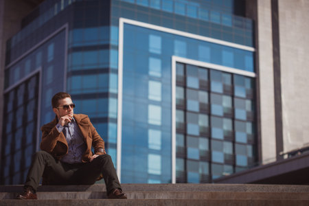 man in front of a glass building wearing coat
