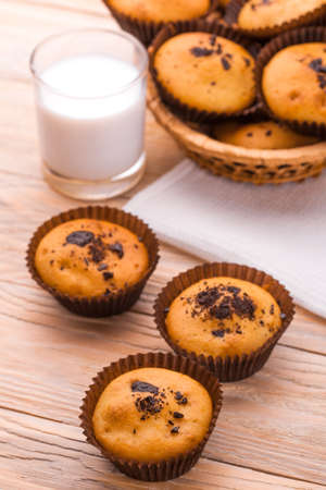 Freshly baked homemade chocolate muffins with milk on the light  tableの写真素材