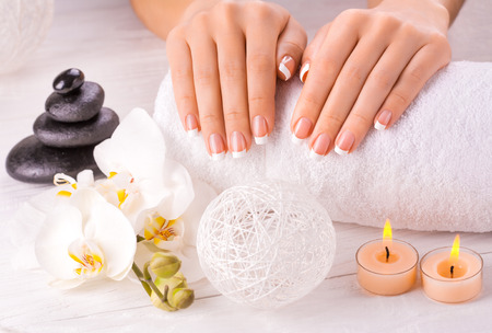 Beautiful hands with manicure and orchid flowerの写真素材