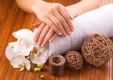 french manicure with white orchid  on a bamboo backgroundの写真素材