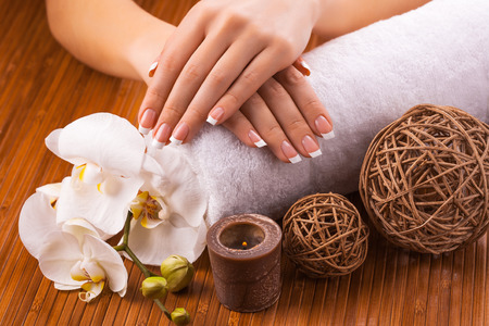 french manicure with white orchid  on a bamboo backgroundの写真素材