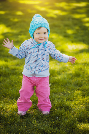 Cute caucasian baby boy in park looks at cameraの写真素材