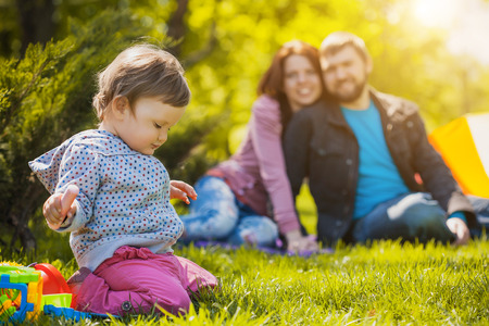 mother and father are plaing with their daughter in the parkの写真素材