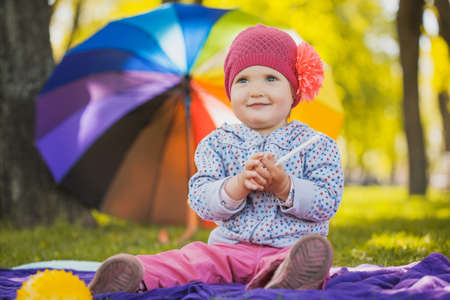 Cute caucasian baby boy in park looks at cameraの写真素材