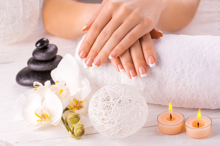 Beautiful hands with manicure and orchid flowerの写真素材