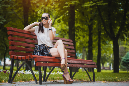 cute Young Woman with smartphone in the parkの写真素材