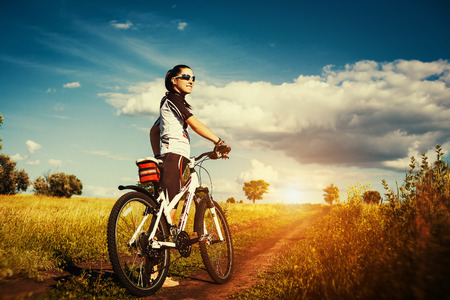 Woman is riding bicycle outside の写真素材