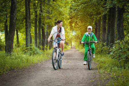 Happy family  mother and son riding bicycle in the parkの写真素材