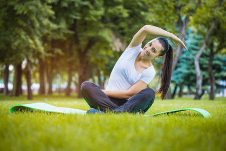 young woman doing exercises in the parkの写真素材