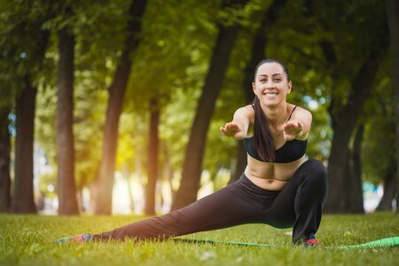 young woman doing exercises in the parkの写真素材