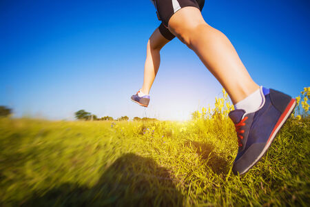 Young woman jogging in the summer parkの写真素材