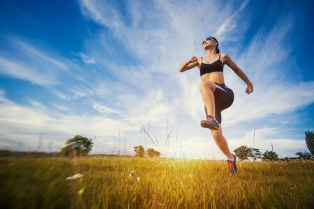 Young woman jogging in the summer parkの写真素材