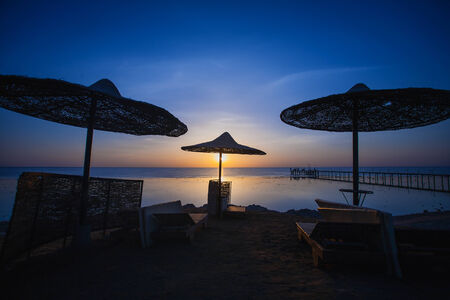 Sunset on the beach with parasolの写真素材