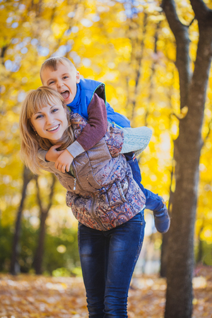 mother and her kid have fun in the autumn parkの写真素材