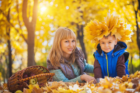mother and her kid have fun in the yellow leavesの写真素材