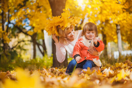 mother and her baby have fun in the autumn parkの写真素材