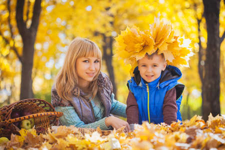mother and her kid have fun in the yellow leavesの写真素材