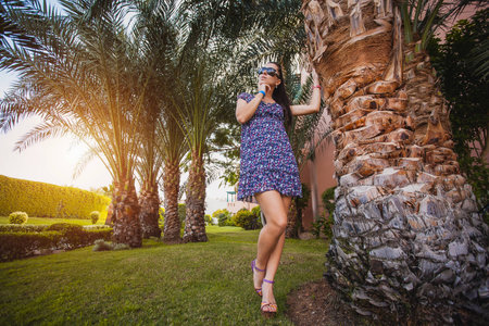 woman is walking in the garden with palm treesの写真素材