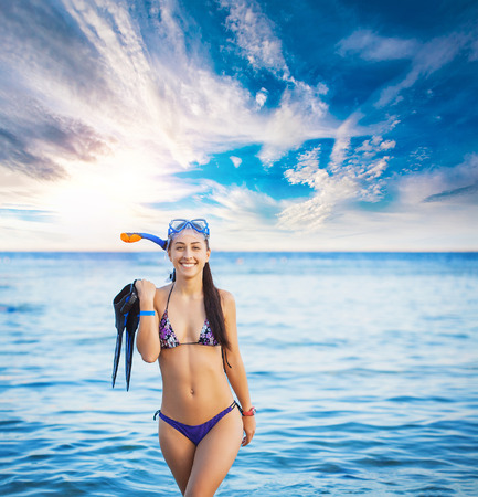 Happy diver woman wearing goggles, tube and flippersの写真素材